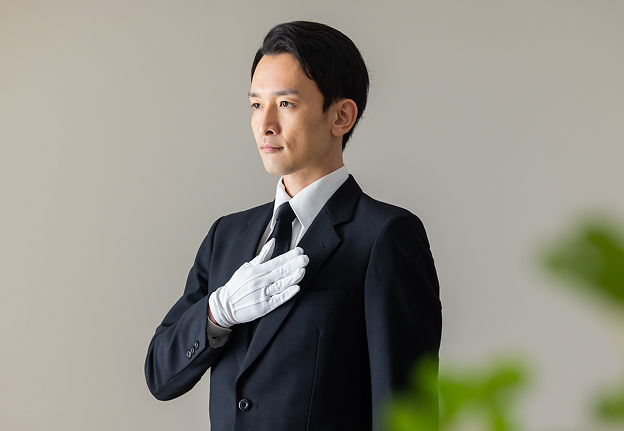 男性スタッフが胸に右手を当てている写真