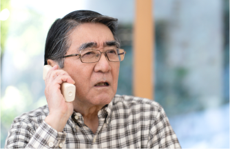 年配の男性が電話で話す様子の写真