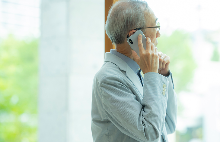 年配の男性が電話をかけている写真
